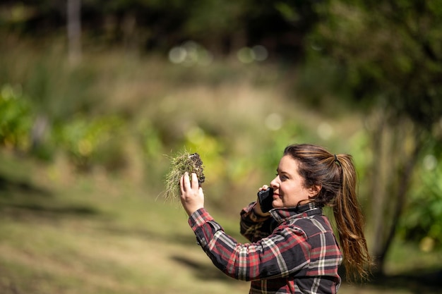 agricoltrice che preleva un campione di terreno da un raccolto in una fattoria