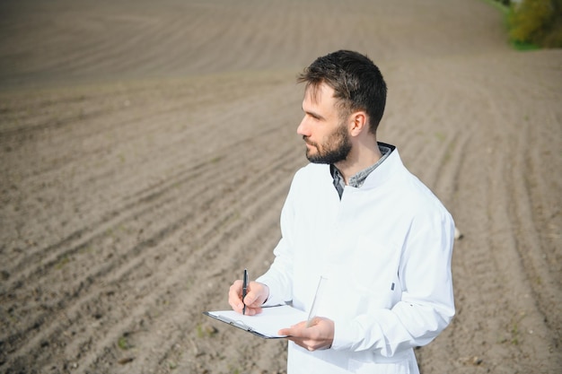 Agronomo che studia campioni di terreno sul campo