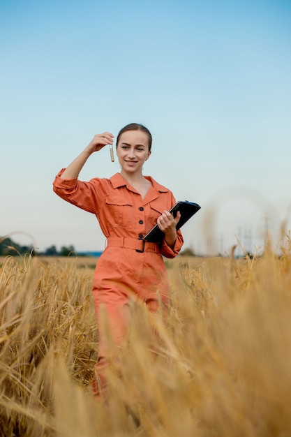 Agronomo che tiene la provetta con i chicchi d'orzo in campo, primo piano. Coltivazione di cereali, oncept di test sul grano