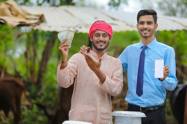 Agronomo indiano che mostra lo schermo dello smartphone con l'agricoltore