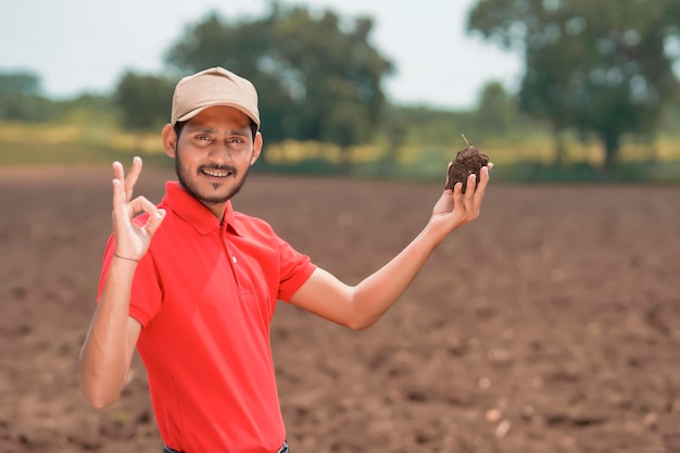 Agronomo indiano che prova il suolo al campo di agricoltura.