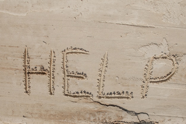 Aiutami l'iscrizione sulla sabbia. Mi aiuti per favore. Su una spiaggia tropicale