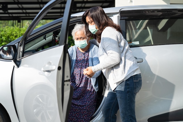 Aiutare e supportare la camminata paziente asiatica anziana o anziana della donna anziana con il deambulatore prepararsi per arrivare alla sua auto sano concetto medico forte
