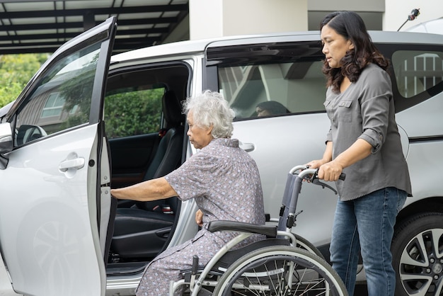 Aiutare e supportare la paziente anziana asiatica anziana o anziana che si prepara a raggiungere la sua auto.