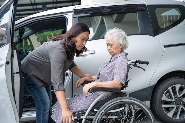 Aiutare e supportare la paziente asiatica anziana o anziana anziana prepararsi per raggiungere la sua auto.