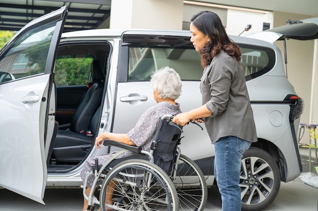 Aiutare e supportare la paziente asiatica anziana o anziana della donna anziana prepararsi per arrivare alla sua macchina