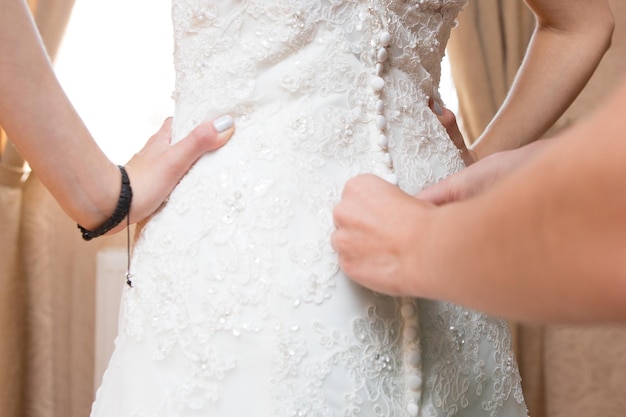 Aiutare la sposa a indossare l'abito da sposa