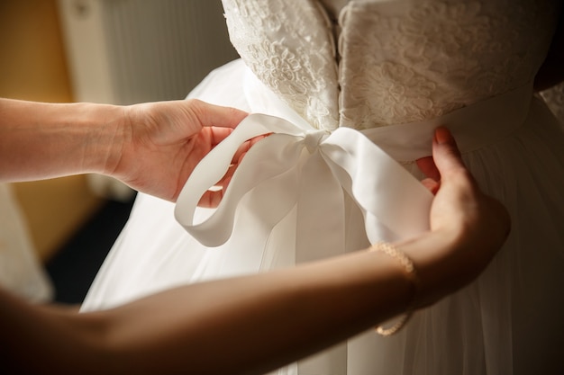 Aiuto damigella d'onore nel camerino per la sposa. Mattina di nozze