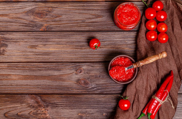 Ajvar o pindjur diffusione di verdure rosse o pepe paprika e mousse di pomodoro in una ciotola di argilla su un tavolo di legno rustico.