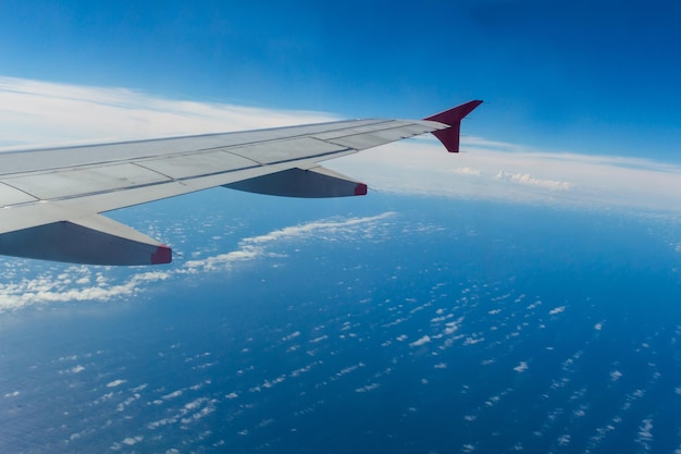 Ala dell'aeroplano con sfondo blu cielo e oceano