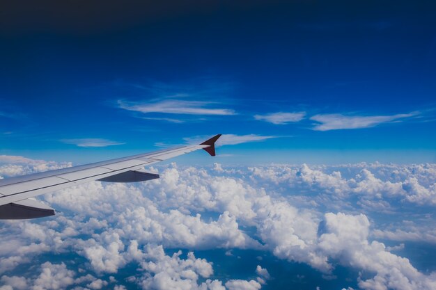 Ala di aereo sulle nuvole e sul cielo blu