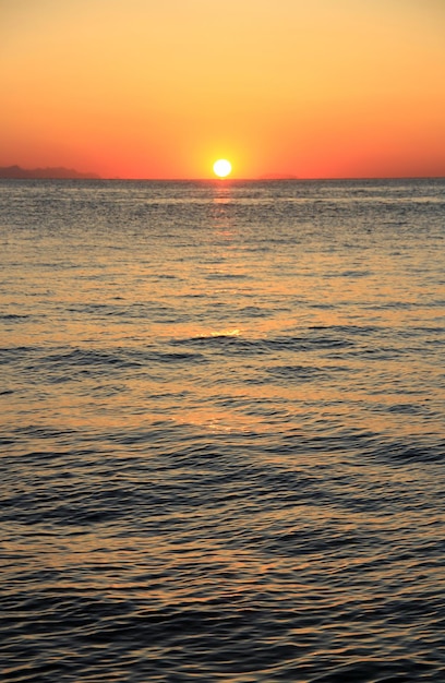 Alba al mare. Cielo arancione. Onde.