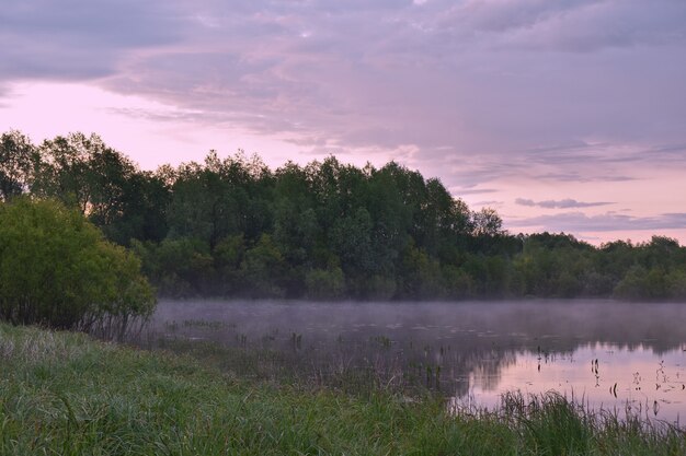 Alba colorata e nebbiosa su un piccolo fiume