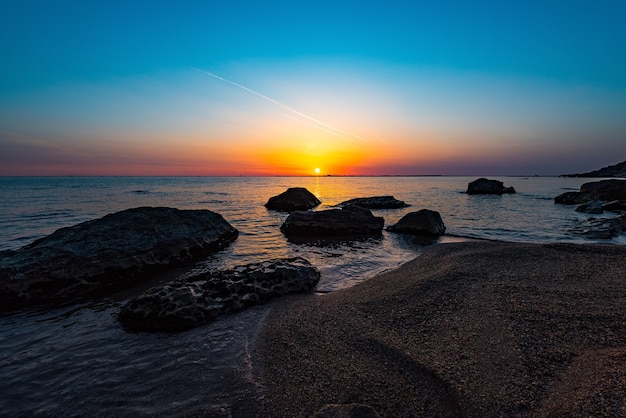 Alba colorata in riva al mare