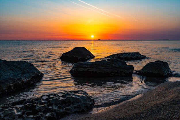 Alba colorata in riva al mare