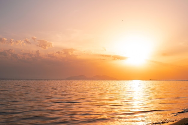 Alba colorata sulla spiaggia dell'oceano con cielo blu profondo e raggi del sole albania