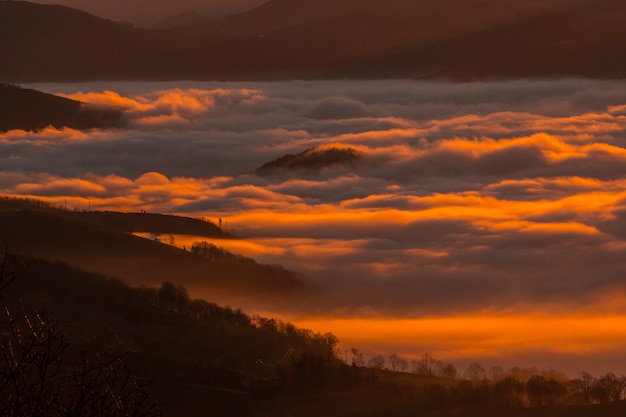 Alba con una fitta nebbia arancione in una mattina d'inverno