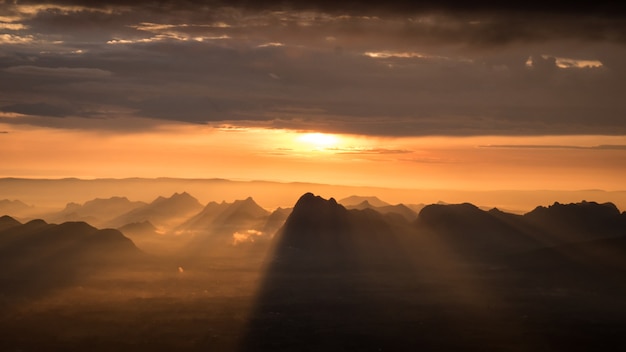 Alba del mattino, il cielo è rosso e arancione. Il sole splende attraverso la foresta e il