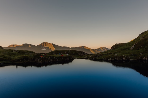 Alba, in vista del lago di capra, tende nei Carpazi, Fagaras, Romania, all'aperto