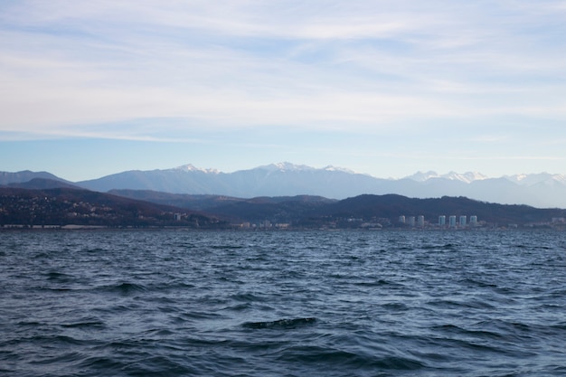 Alba nella foschia rosa del mare del sole che sorge sopra la città del mare e le montagne all'orizzonte sochi ...