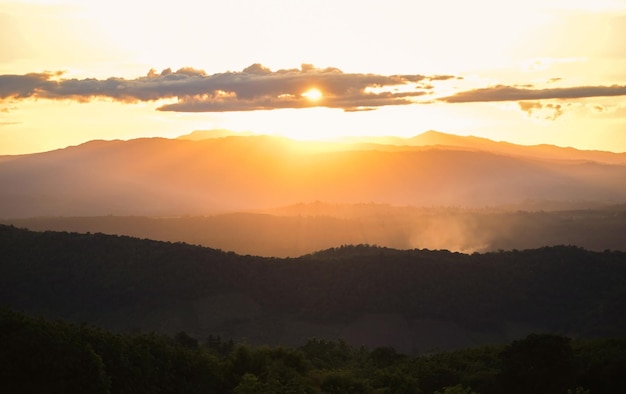 Alba o tramonto bellissimo cielo la luce del sole splende il cielo con nuvole colorate e sfondo di montagna Nuvola crepuscolare sul cielo