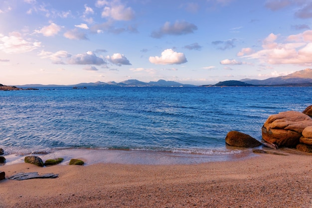 Alba romantica di mattina nella spiaggia di Capriccioli della Costa Smeralda nel Mar Mediterraneo sull'isola di Sardegna in Italia. Cielo con nuvole. Pietre e rocce.
