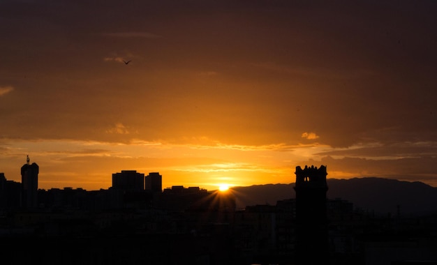 Alba su Napoli, Italia. Sole nascente con sagome di edifici. Concetto di mattina e alba.