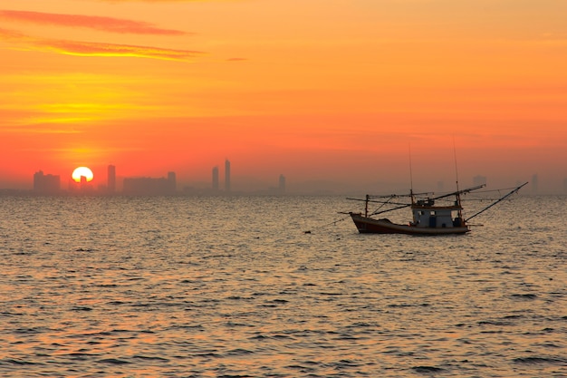 Alba sul mare con barca da pesca