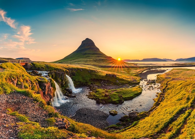 Alba sul monte vulcanico Kirkjufell con cascata che scorre in estate in Islanda