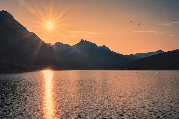 Alba sulle montagne rocciose canadesi con cielo colorato sul lago di medicina al parco nazionale di Jasper, Canada