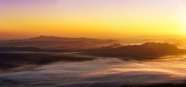 Alba sullo sfondo di montagne nebbiose.