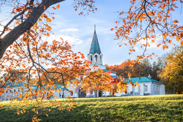 Alberi autunnali dorati e il cancello anteriore nel parco di Kolomenskoye a Mosca in una giornata di sole autunnale