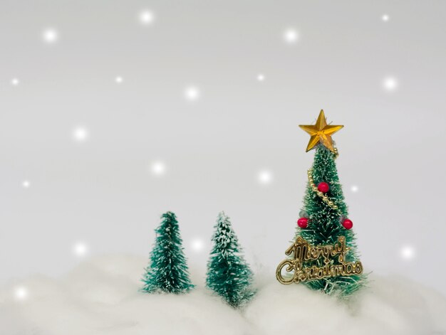 Alberi di Natale artificiali decorati con stelle, ornamenti e neve.