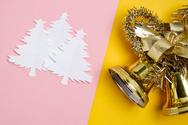 Alberi di Natale fatti di carta bianca con campane di Natale dorate