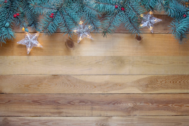 Albero di abete e ghirlanda di Natale su fondo di legno. Copi lo spazio
