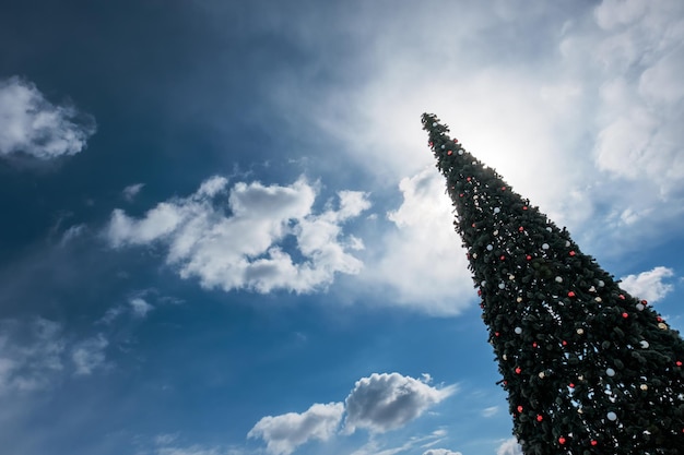 Albero di Natale artificiale sullo sfondo di un cielo azzurro Decorazione festiva di strada