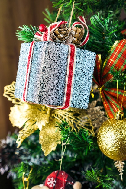 Albero di Natale assemblato con ornamenti. Palline rosse, argento e oro, scatole regalo, luci, Babbo Natale e altri. Messa a fuoco selettiva.