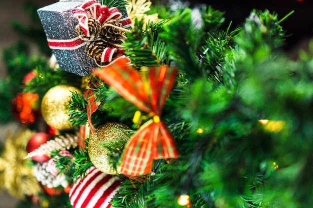 Albero di Natale assemblato con ornamenti. Palline rosse, argento e oro, scatole regalo, luci, Babbo Natale e altri. Messa a fuoco selettiva.