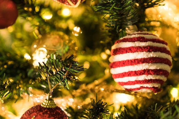 Albero di Natale assemblato con ornamenti. Palline rosse, argento e oro, scatole regalo, luci, Babbo Natale e altri. Messa a fuoco selettiva.