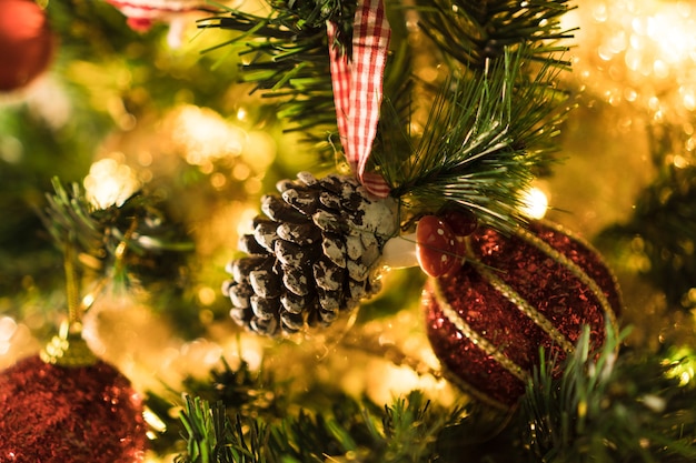 Albero di Natale assemblato con ornamenti. Palline rosse, argento e oro, scatole regalo, luci, Babbo Natale e altri. Messa a fuoco selettiva.