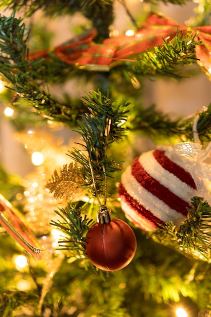 Albero di Natale assemblato con ornamenti. Palline rosse, argento e oro, scatole regalo, luci, Babbo Natale e altri. Messa a fuoco selettiva.