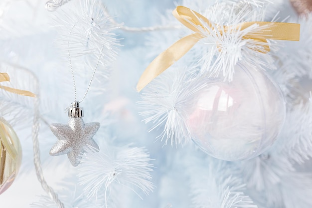 Albero di Natale bianco decorato con palline di Natale rosa dorato argento e bellissime palline di vetro su ramo blu bianco scintillante e fata, luci decorative, spazio copia. Foto.