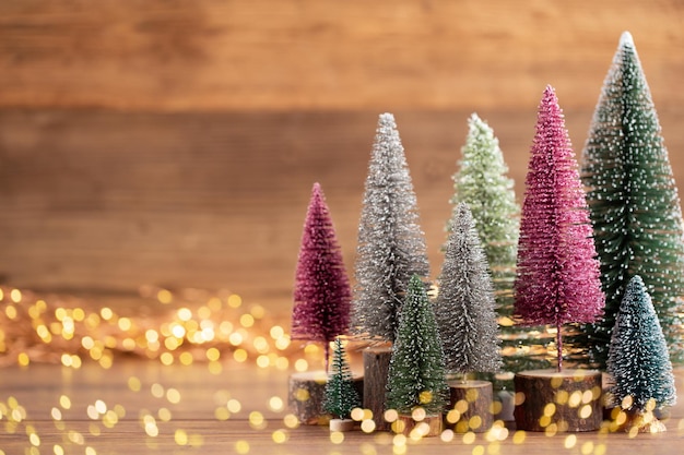 Albero di Natale colorato su legno, sfondo bokeh. Concetto di celebrazione delle vacanze di Natale. Biglietto d'auguri.