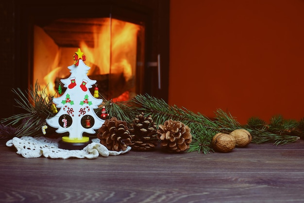 Albero di Natale con coni dal caminetto acceso