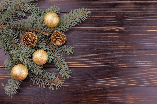 Albero di Natale con coni su palline dorate su uno sfondo di legno Copia spazio