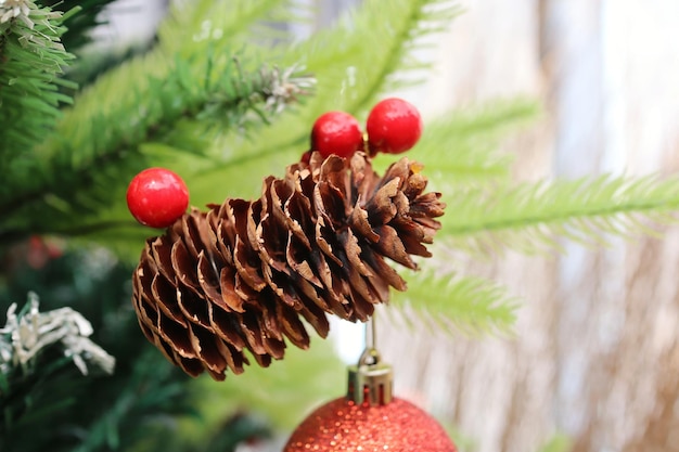 Albero di Natale con decorazione rosso ciliegia e semi di pino Messa a fuoco selettiva con foto in stile vintage.