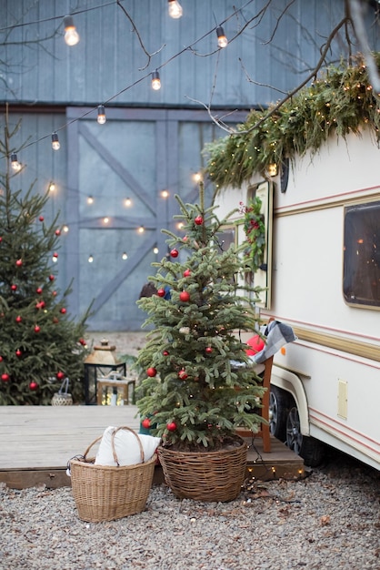 Albero di Natale con decorazioni all'aperto vicino al trailer di viaggio Accoglienti decorazioni natalizie all'aperto