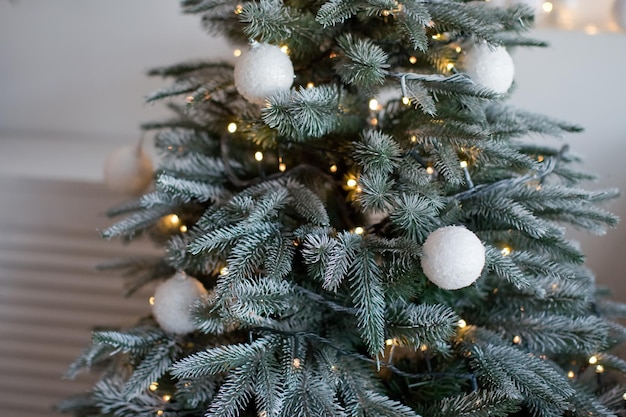 Albero di Natale con decorazioni bianche di palline di Natale e luci di Natale