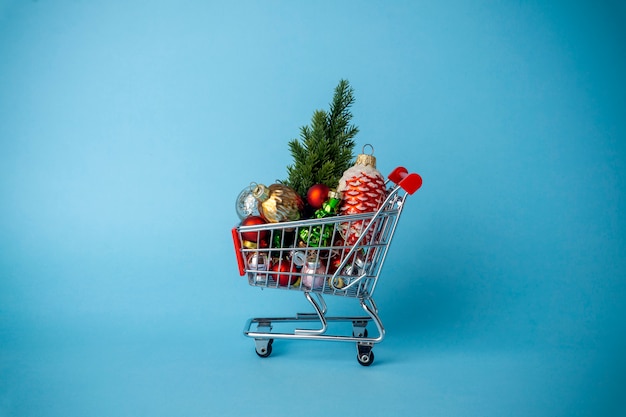 Albero di Natale con decorazioni in un carrello del supermercato