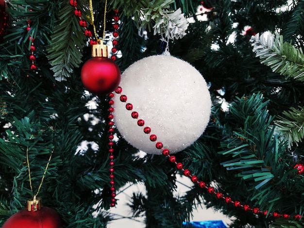 Albero di Natale con decorazioni Palle di Natale e giocattoli Ornamenti pendenti rossi e bianchi Palline grandi e piccole perline rosse
